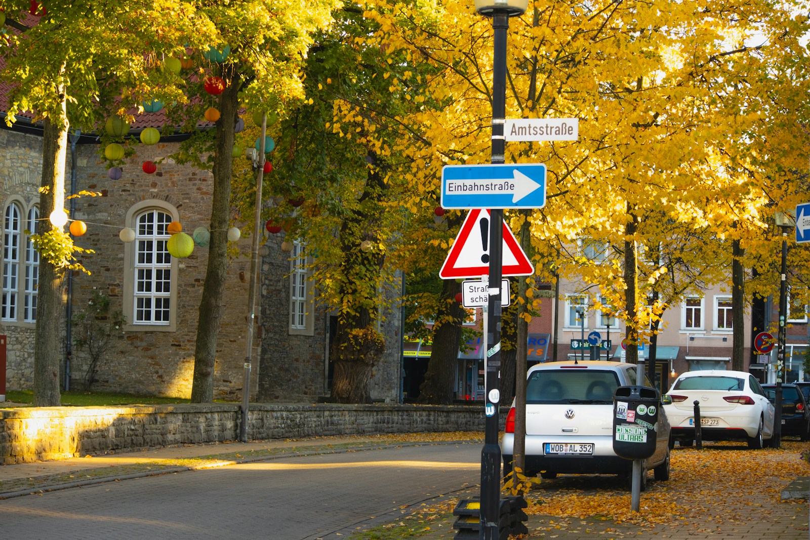 A street with a bunch of cars parked on the side of it
